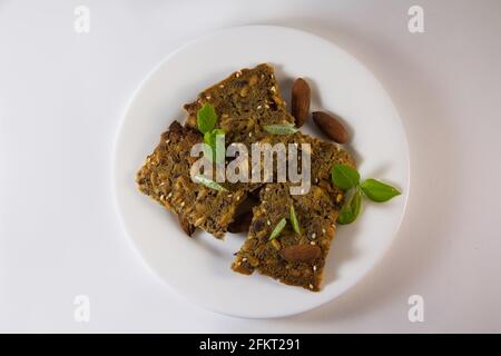 Whole grain homemade crispbread in the white plate on white background. Healthy lifestyle breakfast Stock Photo