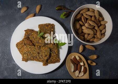 Whole grain homemade crispbread and almonds on dark background. Healthy lifestyle breakfast Stock Photo