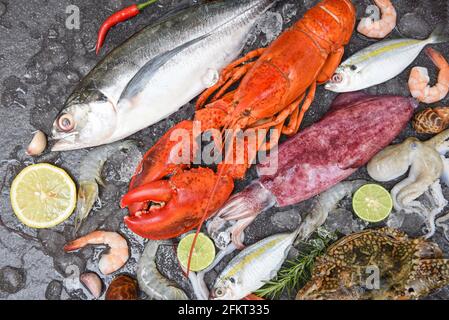 Fresh raw seafood on ice with herbs and spices at the fish market food, Fresh fish and seafood plate with Shellfish shrimps prawns crab shell squid oc Stock Photo
