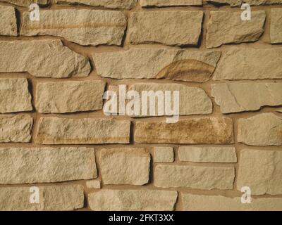 closeup view of sand stone rock wall with colored grout matching with shadows and details Stock Photo