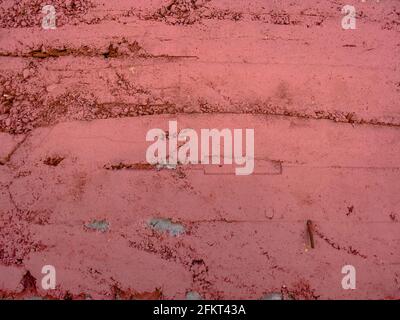 old stone block brick garden wall building painted red and weathered Stock Photo