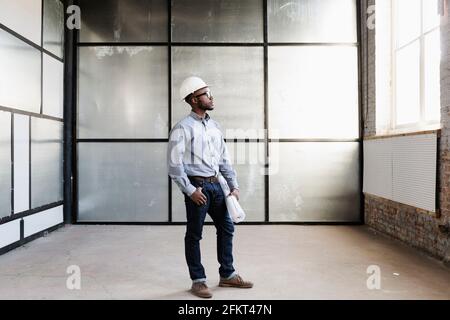 Portrait of young male interior designer in empty room Stock Photo