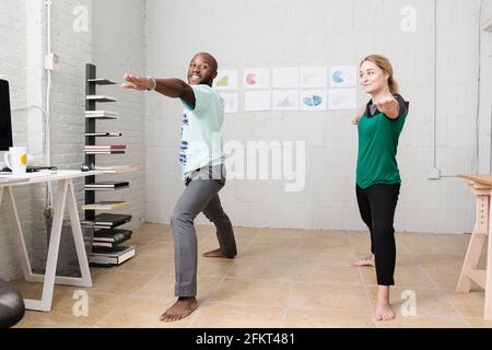 Young business partners doing exercises in design office Stock Photo