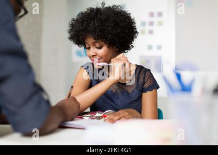 Two colleagues working, woman holding pen Stock Photo