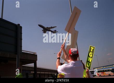 Striking  British Airways cabin crew react to Jumbo jet 1997 as the BA aircraft takes off by waving placards in air Stock Photo