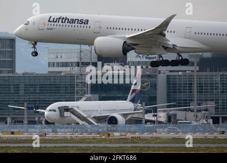 03 May 2021, Hessen, Frankfurt/Main: A Lufthansa passenger aircraft, an Airbus A350-900, lands at Frankfurt Airport. On 04 May, the annual general meeting of the ailing airline takes place as a purely virtual event. The aviation industry is particularly hard hit by the effects of the global Corona pandemic. Photo: Boris Roessler/dpa Stock Photo