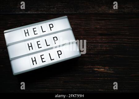 Help word text in light box on wooden background Stock Photo