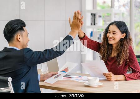 Success business concept, Boss congratulating by give me five action to asian businesswoman in glad action when successful project or getting promote, Stock Photo