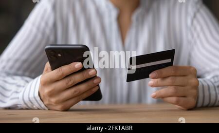 Close up woman paying online by credit card, using smartphone Stock Photo
