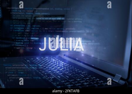 Julia inscription against laptop and code background. Technology concept. Learn programming language. Stock Photo