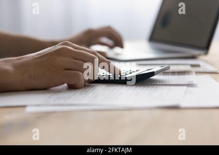 Close up man laptop and calculator, calculating bills, managing finances Stock Photo