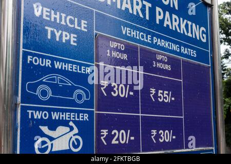 A roadside board showing parking fare for vehicles in North India. Stock Photo