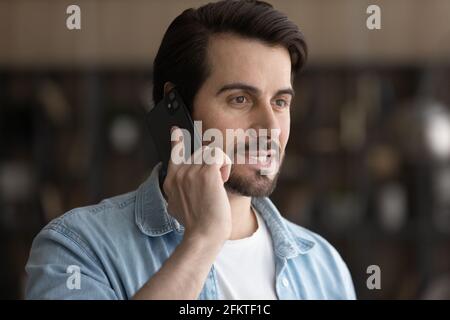Close up smiling man talking on smartphone, making call Stock Photo