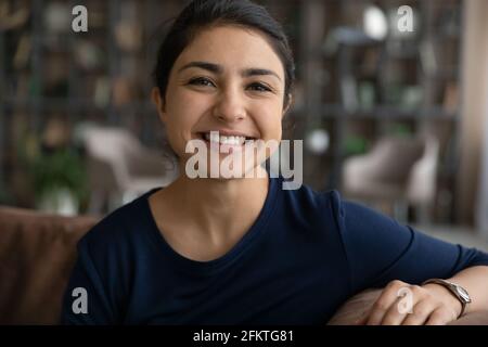 Head shot portrait smiling Indian woman making video call Stock Photo