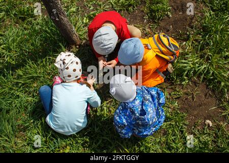 CHELYABINSK, RUSSIA, MAY 09, 2017: children catch beetles in the grass Stock Photo