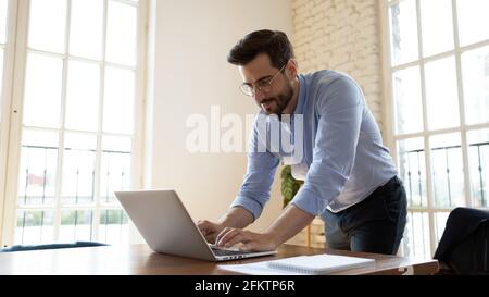 Happy young male manager working on computer. Stock Photo
