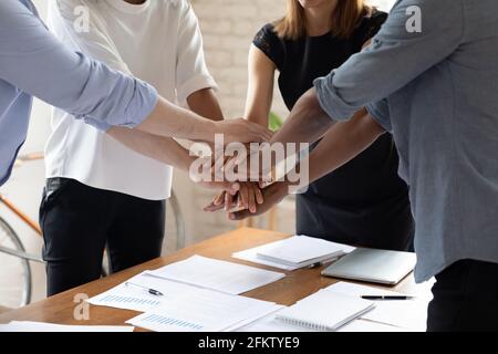 Close up group of multiracial people joining hands together. Stock Photo