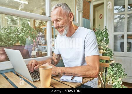 Middle aged caucasian man next to laptop Stock Photo