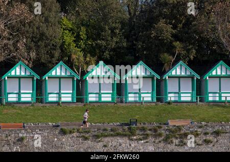 Swansea, UK. 04th May, 2021. A man jogs in front of the wooden beach huts at Langland Bay near Swansea this morning after yesterday's stormy Bank Holiday weather. Credit: Phil Rees/Ģ����ý Live News Stock Photo
