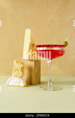 Still life of rose wine, cheese and honey in combs. Front view on a yellow and light green background. Stock Photo