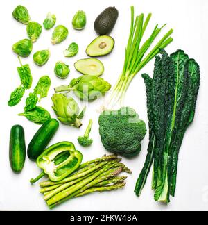 Green vegetables and herbs assortment on a white background. Flat lay series of assorted green vegetables. Fresh organic produce. Healthy food. Top vi Stock Photo
