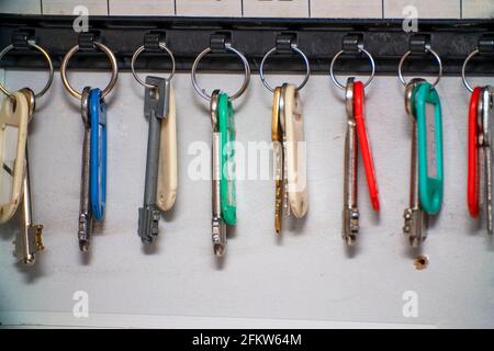 The keys to the doors with tags hang on hooks in a special drawer. Selective focus Stock Photo