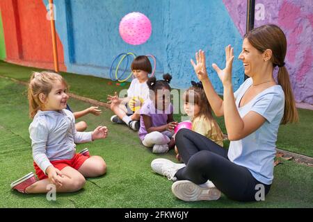 Children play ball together with the gym teacher in the international kindergarten Stock Photo