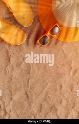Summer beach holiday concept, flat lay top view with hat, sunglasses and flip flop slippers on sand background as copy space Stock Photo