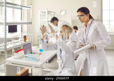 Scientist group in eyewear working at research chemistry medical laboratory Stock Photo