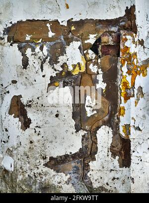 Heavily distressed and textured paint on a plaster wall Stock Photo