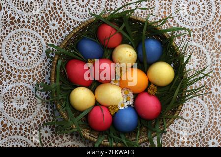 Colorful Easter eggs in a basket made up with flowers Stock Photo
