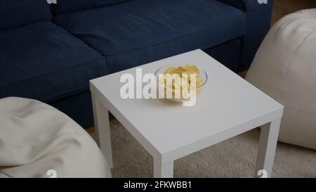 Front view of empty room with nobody in it prepared for night party. Living room having potato chips bowl on woden table, apartament is ready for friends gathering celebrating wekeend birthday Stock Photo