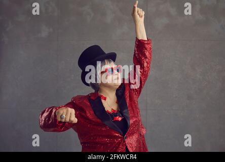 Funny senior woman in a party jacket dancing, having fun and feeling free and happy Stock Photo