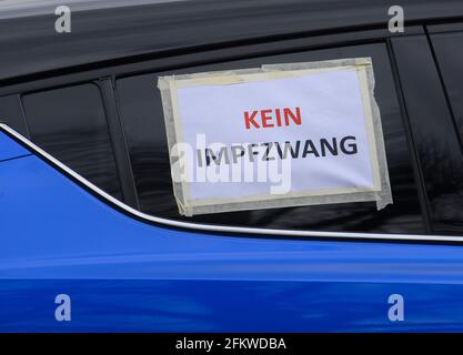 Dresden, Germany. 01st May, 2021. Notes with crossed out syringes, a Saxony  flag and a Germany flag are attached to a car during a motorcade of the  initiative Querdenken 351. Under the