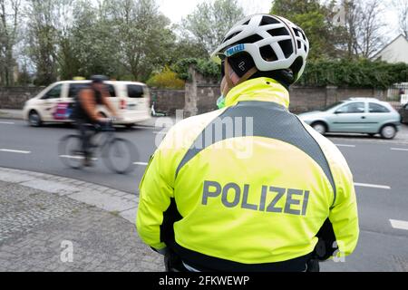 Dresden, Germany. 04th May, 2021. A police officer stands in front of a cyclist on a road during a press event to launch the 'Respect through consideration' campaign. The distance to the side of vehicles when overtaking cyclists is being checked. Credit: Sebastian Kahnert/dpa-Zentralbild/dpa/Alamy Live News Stock Photo