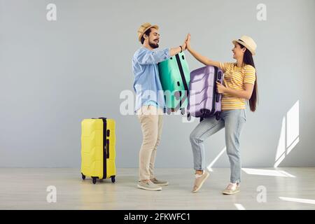 Giving high five tourists couple or friends giving high five full body portrait Stock Photo