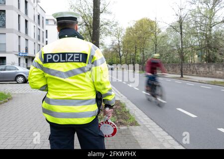 Dresden, Germany. 04th May, 2021. A police officer stands in front of a cyclist on a road during a press event to launch the 'Respect through consideration' campaign. The distance to the side of vehicles when overtaking cyclists is being checked. Credit: Sebastian Kahnert/dpa-Zentralbild/dpa/Alamy Live News Stock Photo