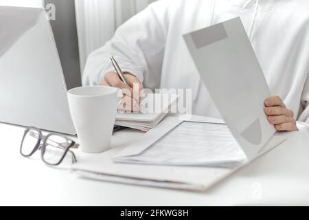 A female make a note at work. Close-up Stock Photo