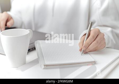 A female make a note at work. Close-up Stock Photo