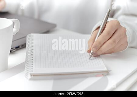 A female make a note at work. Close-up Stock Photo