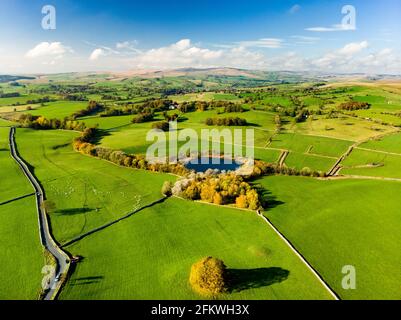 Aerial view of endless lush pastures and farmlands of England. Beautiful English countryside with emerald green fields and meadows. Rural landscape on