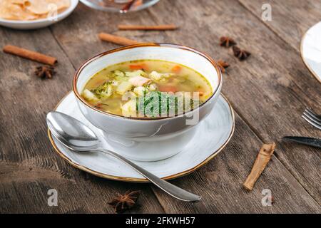 Bowl of vegetable chicken soup on wooden table Stock Photo