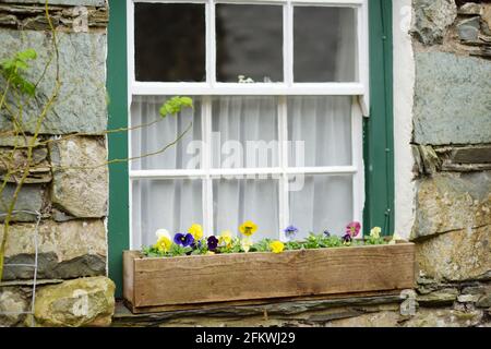 Houses of Stonethwaite village, beautifully decorated with flowers and greenery. Small village situated in the valley of the Stonethwaite Beck. Explor Stock Photo