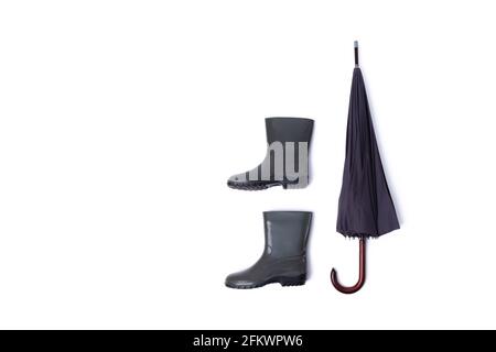 Rubber shoes and umbrella isolated on white background. Rain season and weather forecast. Nobody Stock Photo