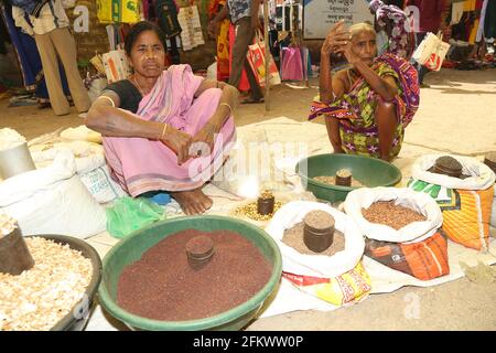 Weekly tribal market of Vishwanathpur village. Tribal women selling different types of millets and grains. Odisha, India Stock Photo
