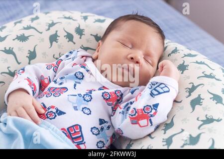 Baby sleeping with arm on belly and with top view Stock Photo