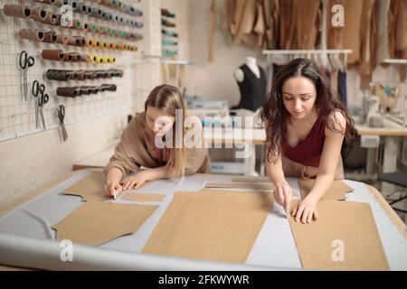 female tailors working with sewing pattern in atelier studio workshop Stock Photo
