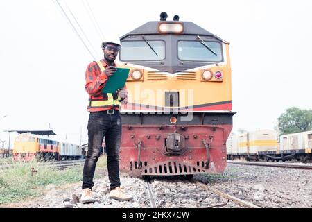 African engineer   control and check report of the train on railway Stock Photo