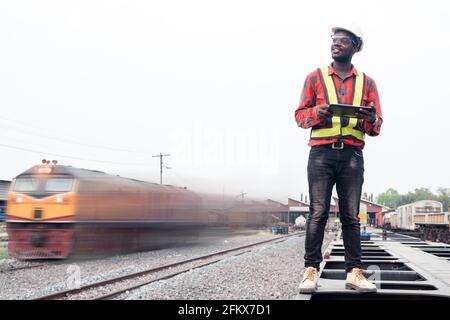 African engineer   control and check report of the train on railway with using tablet Stock Photo
