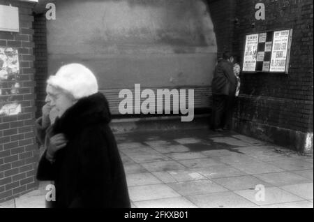 1960s Brighton cold winter weather, two senior women out walking together and young couple kissing in corner out of the wind. 1969 East Sussex UK HOMER SYKES Stock Photo